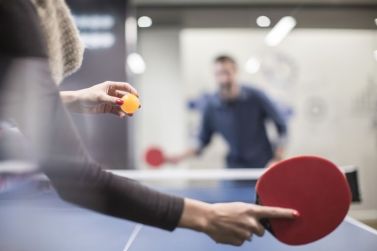 two-colleagues-playing-table-tennis-in-office-break-room-673117017-592611993df78cbe7e959740